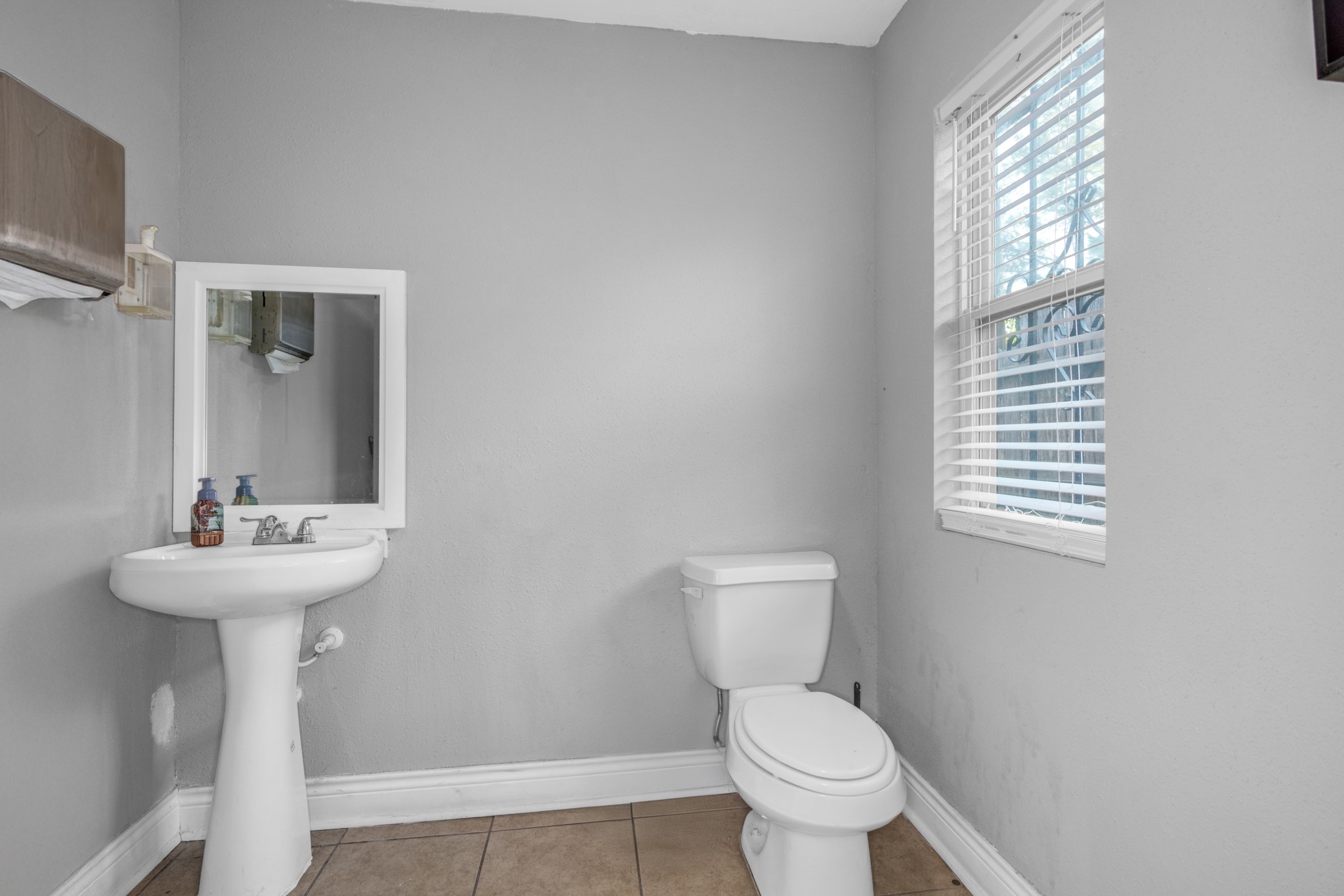10041 Fulton Street Houston, TX 77076 - Photo 21 of 29 a bathroom with a sink a toilet and a window