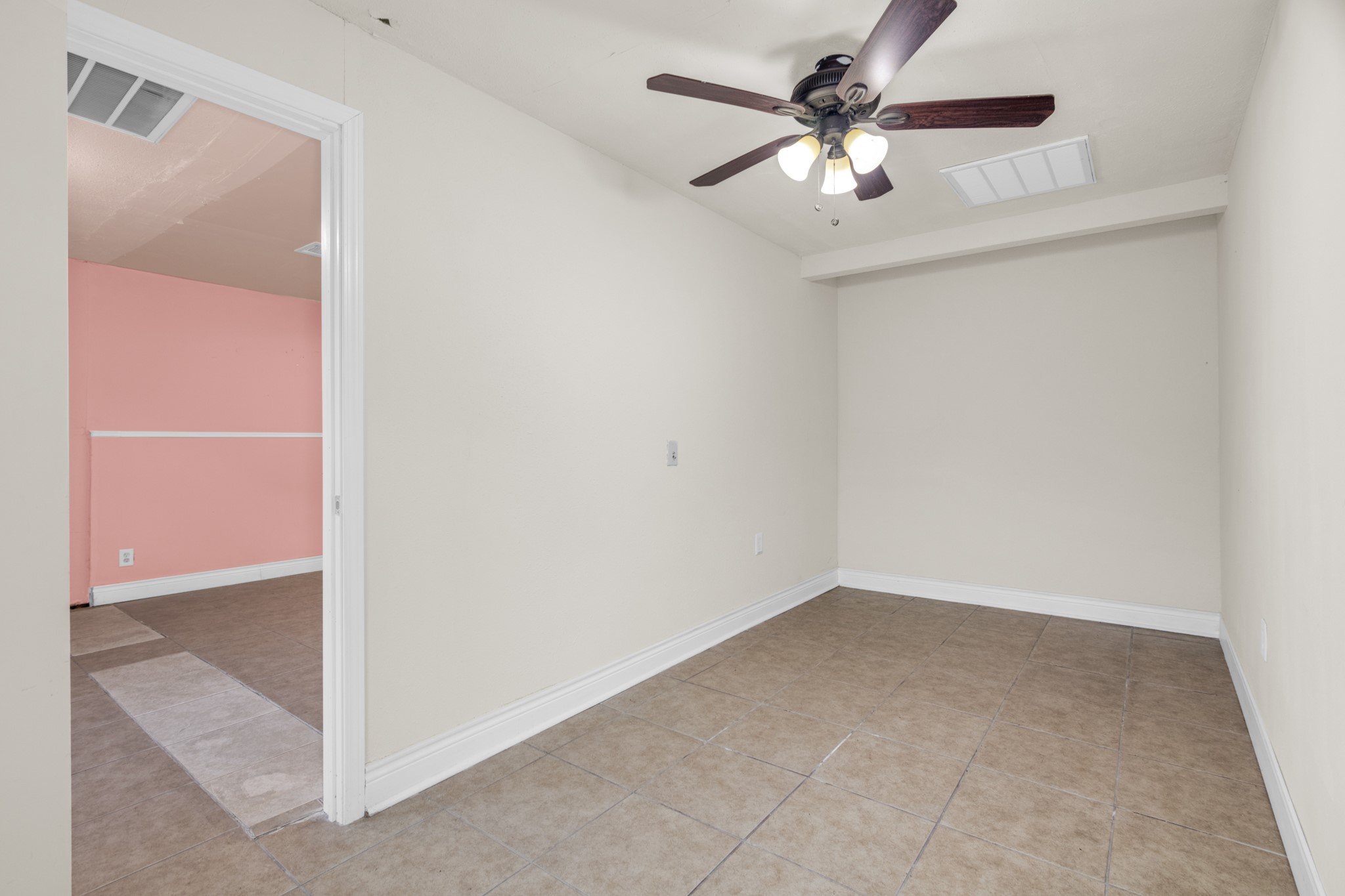 10041 Fulton Street Houston, TX 77076 - Photo 3 of 29 an empty room with a chandelier fan and windows