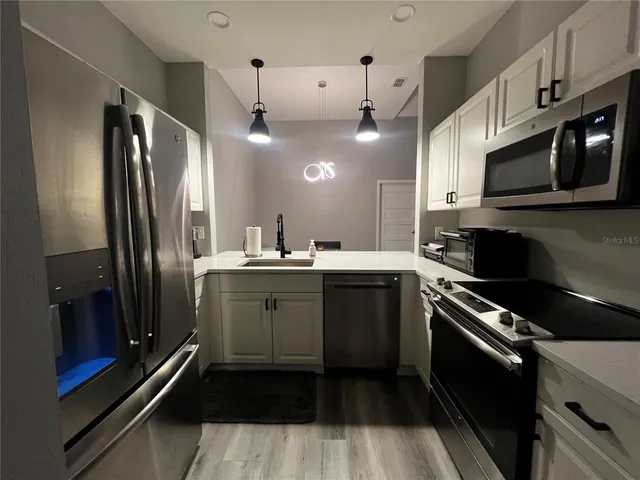 a kitchen with a sink stainless steel appliances and cabinets