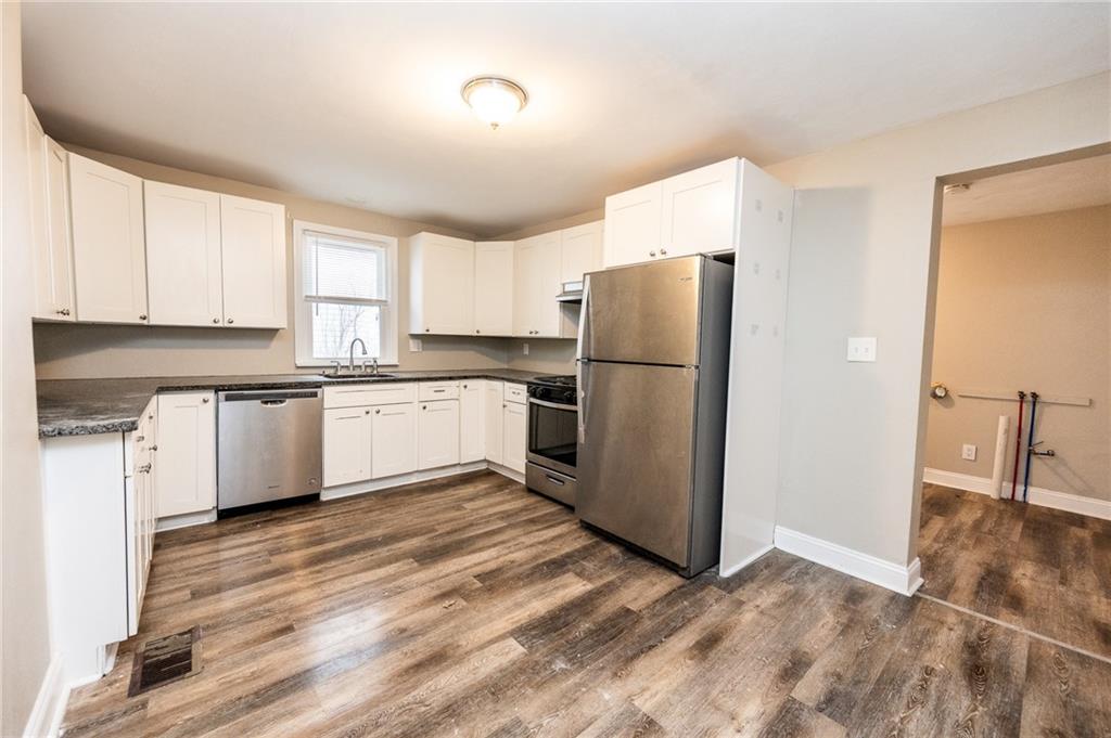 105 Washington Street Mount Pleasant, PA 15666 - Photo 8 of 29 a kitchen with a refrigerator a sink and cabinets
