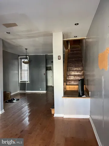 a view of a hallway with wooden floor and a living room