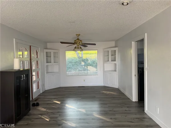 an empty room with wooden floor and windows
