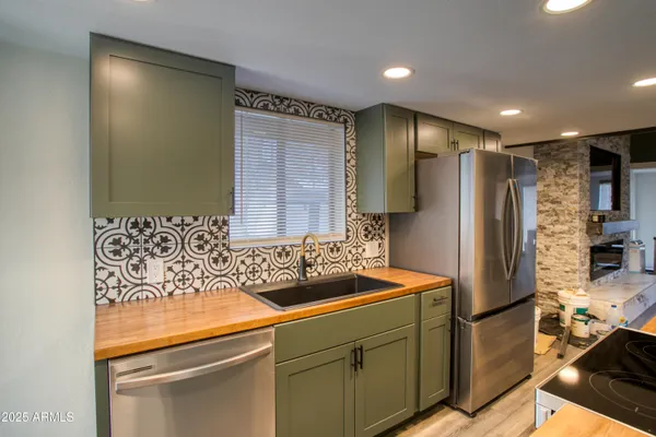 a kitchen with stainless steel appliances granite countertop a refrigerator and a sink