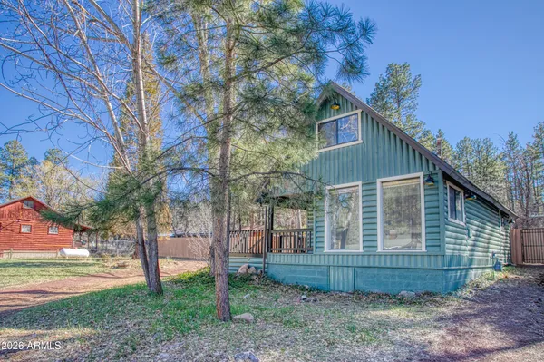a view of a house with a yard and large tree