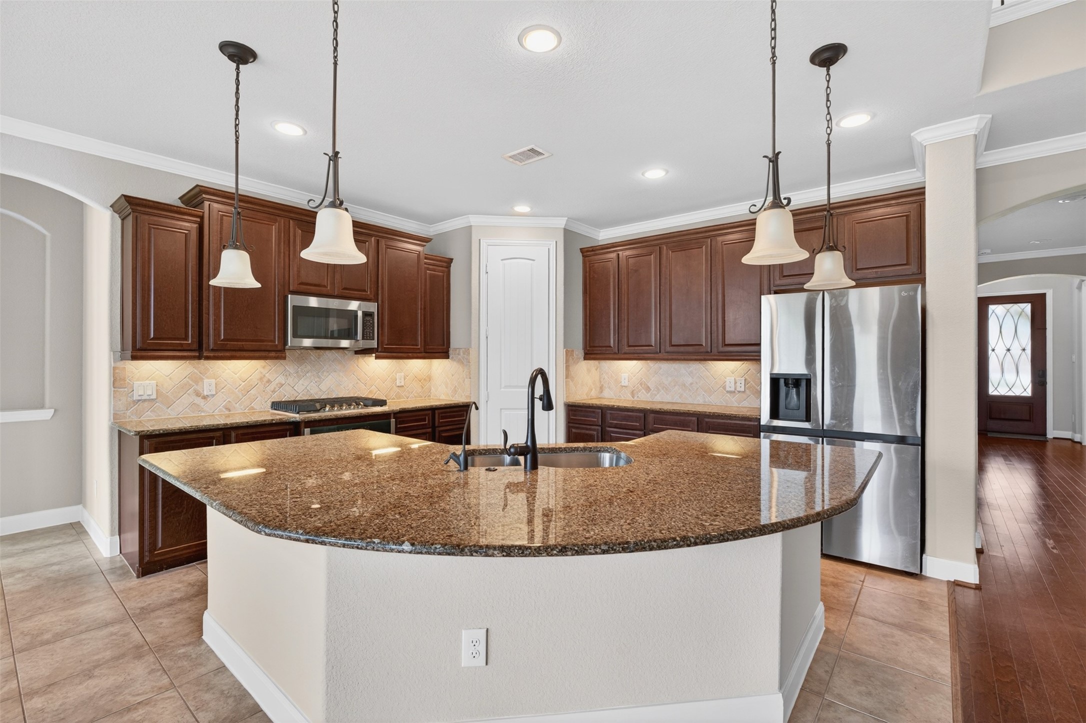 18202 Wedgewood Bluff Court Spring, TX 77379 - Photo 20 of 50 Kitchen island with granite countertop, pendant lighting, and plenty of prep space.