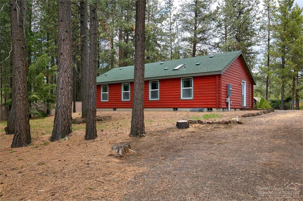 17171 Island Loop Way Bend, OR 97707 - Photo 19 of 25 a backyard of a house with a large tree and wooden fence