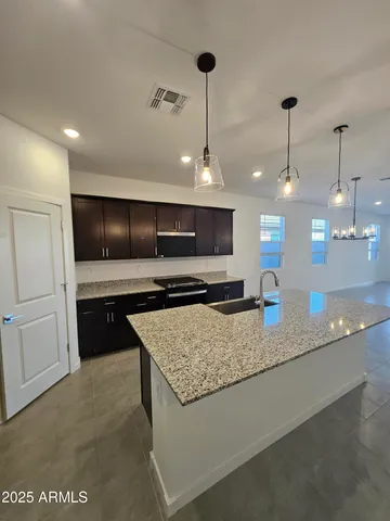 a kitchen with stainless steel appliances granite countertop a sink a stove and a refrigerator