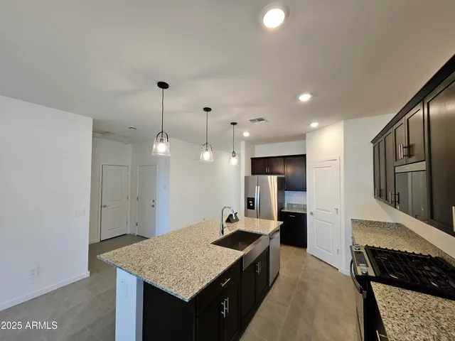 a view of a room with wooden floor and kitchen view