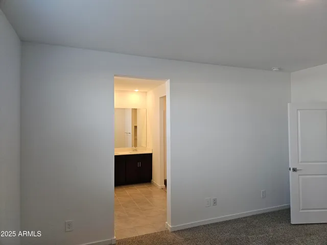 a view of a patio with table and chairs under an umbrella with large trees
