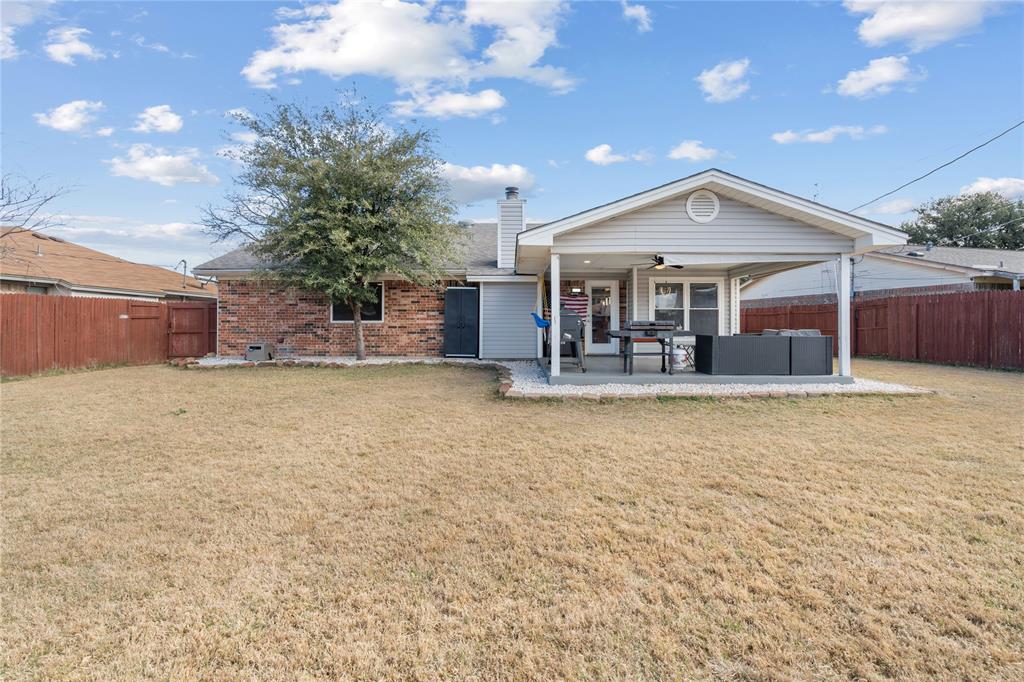 7629 Cedarhill Road Watauga, TX 76148 - Photo 23 of 26 Expansive backyard featuring a covered patio, ceiling fan, and mature tree