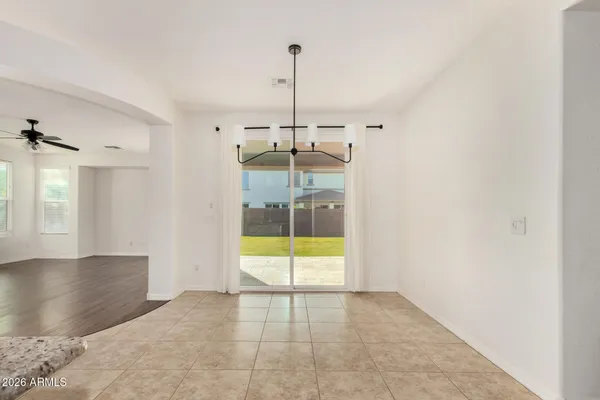 an empty room with wooden floor and a ceiling fan