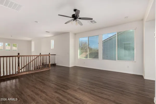 a view of a livingroom with a ceiling fan & windows