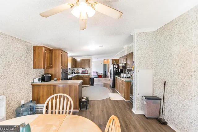a kitchen with a dining table chairs stove and refrigerator