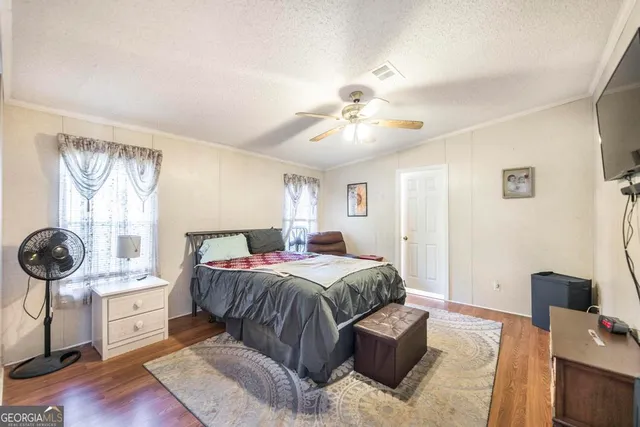 a spacious bedroom with a bed and a flat screen tv