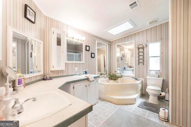 a bathroom with a tub a sink and a large mirror