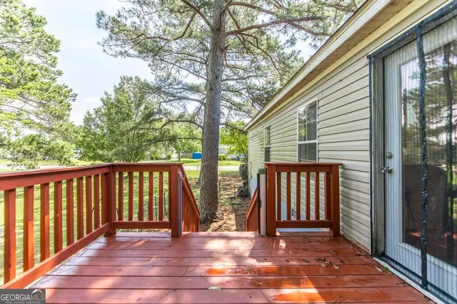 a view of a backyard with large trees and a barn