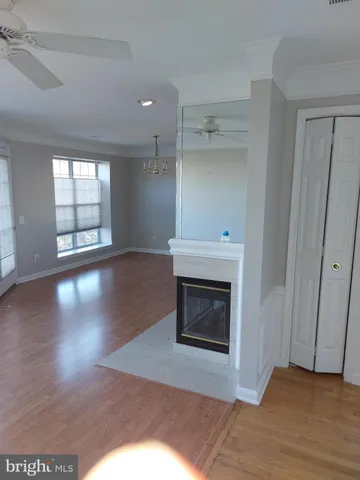 an empty room with wooden floor a fireplace and windows