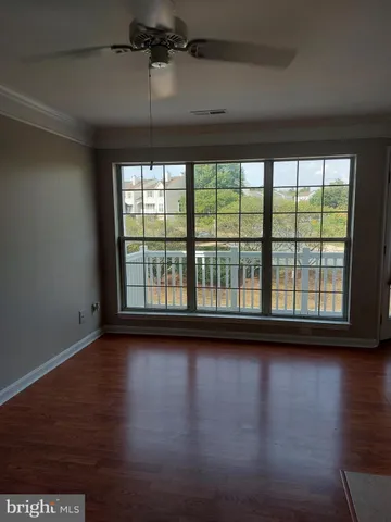 a view of room with wooden floor and windows