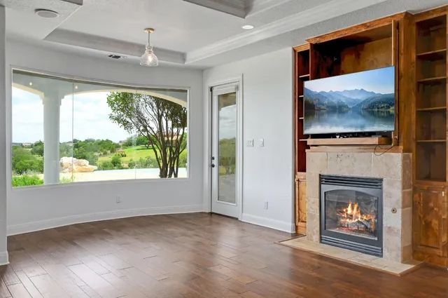 a view of an empty room with window and fire place