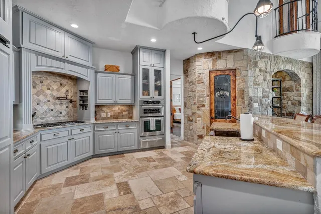 a large kitchen with stainless steel appliances granite countertop a sink and cabinets