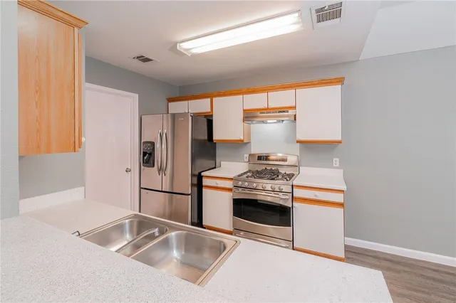 a kitchen with stainless steel appliances granite countertop a refrigerator and a sink