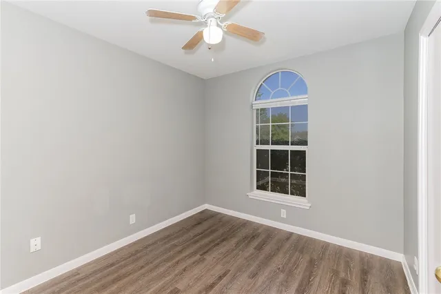 an empty room with a window and wooden floor
