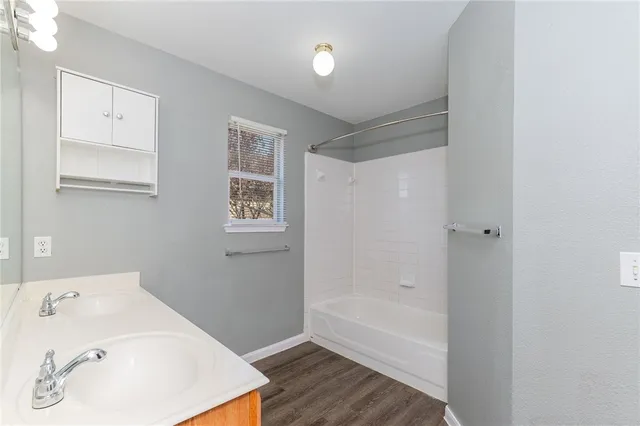a bathroom with a tub sink and mirror