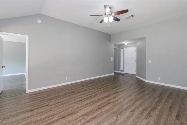 a view of empty room with wooden floor