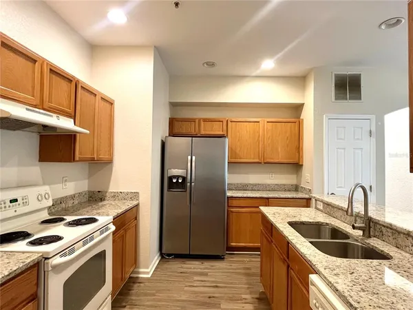 a kitchen with stainless steel appliances granite countertop a sink stove and refrigerator