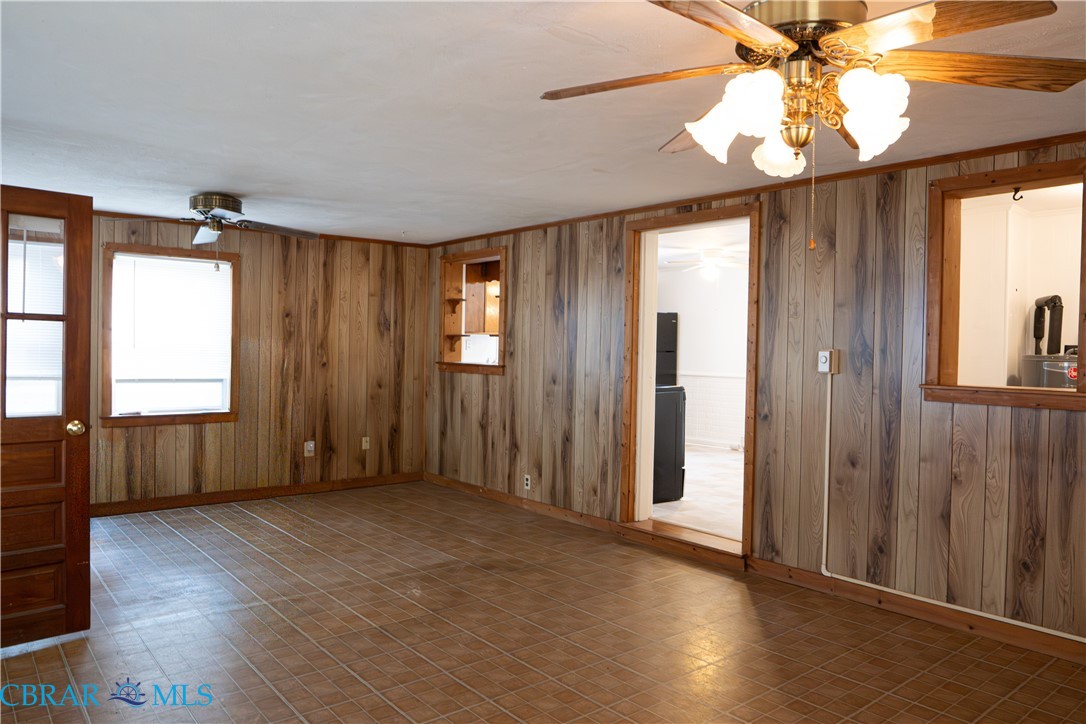1008 Mill Creek Road Wake, VA 23176 - Photo 16 of 22 Empty room with ceiling fan and wooden walls