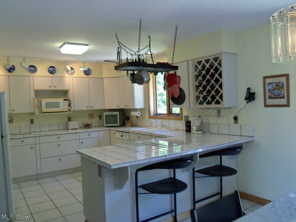 2201 Bennett Road Madison, OH 44057 - Photo 5 of 25 YOU WILL NEVER LACK FOR CUPBOARD SPACE IN THIS SPACIOUS KITCHEN.