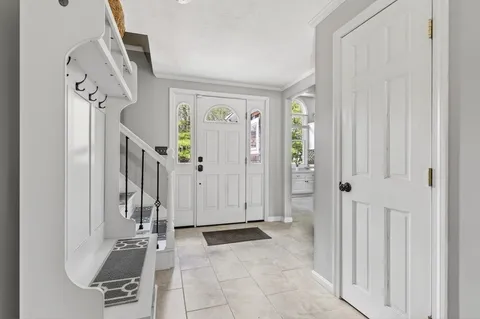 a view of a livingroom with entryway furniture and floor to ceiling window