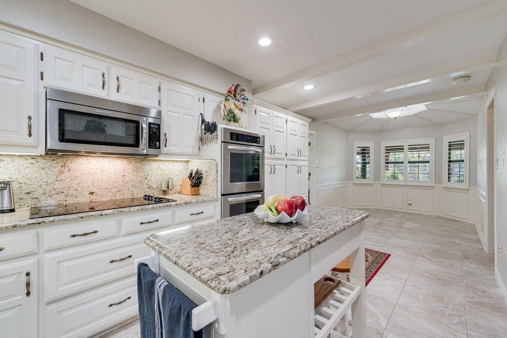 802 Riva Ridge Wylie, TX 75098 - Photo 13 of 39 a kitchen with granite countertop a sink stainless steel appliances and white cabinets