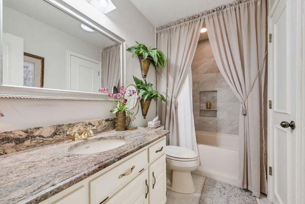 802 Riva Ridge Wylie, TX 75098 - Photo 26 of 39 a bathroom with a granite countertop sink a toilet and shower
