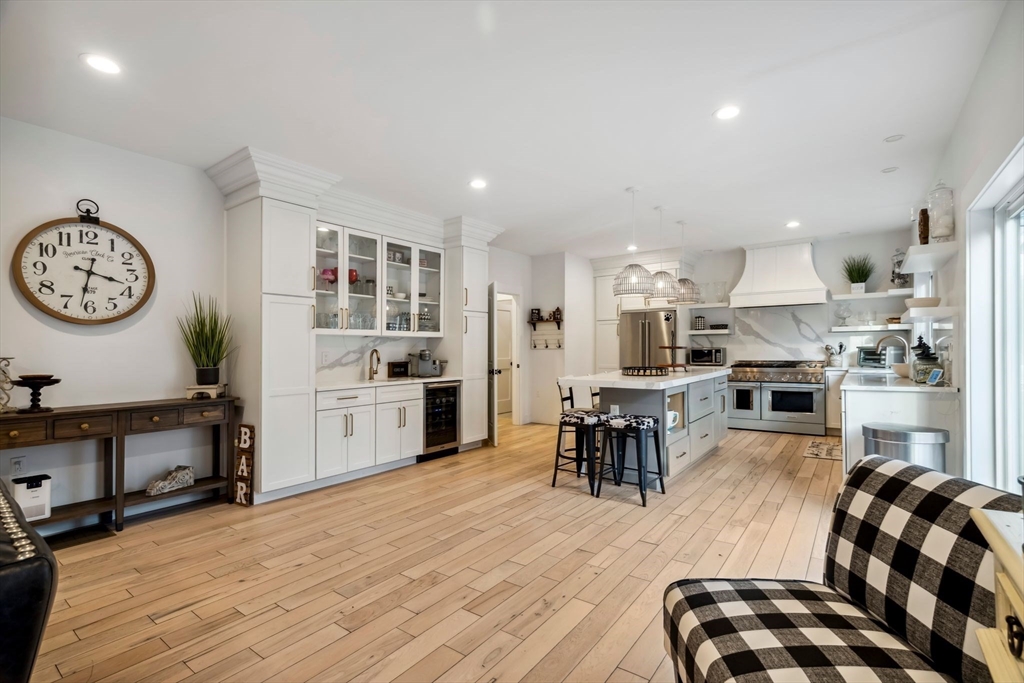 58 Folly Mill Road Salisbury, MA 01952 - Photo 7 of 31 a kitchen with stainless steel appliances granite countertop a refrigerator oven a sink dishwasher a dining table and chairs with wooden floor