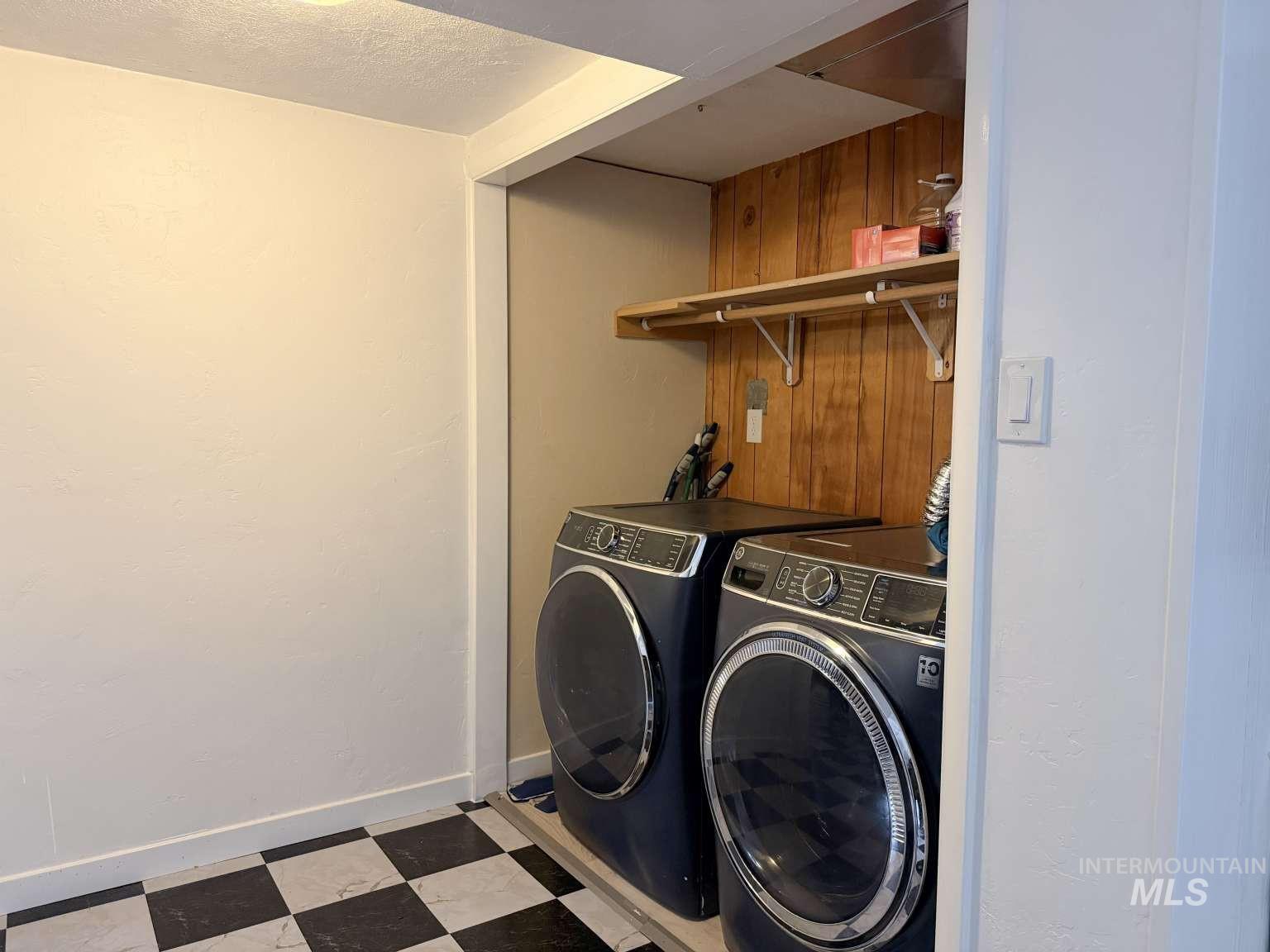 1158 South Powerline Road Nampa, ID 83686 - Photo 40 of 46 Dedicated laundry area featuring front-loading machines, checkered flooring, wood paneling, and built-in shelving