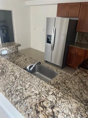 a kitchen with granite countertop a stove a microwave and a sink