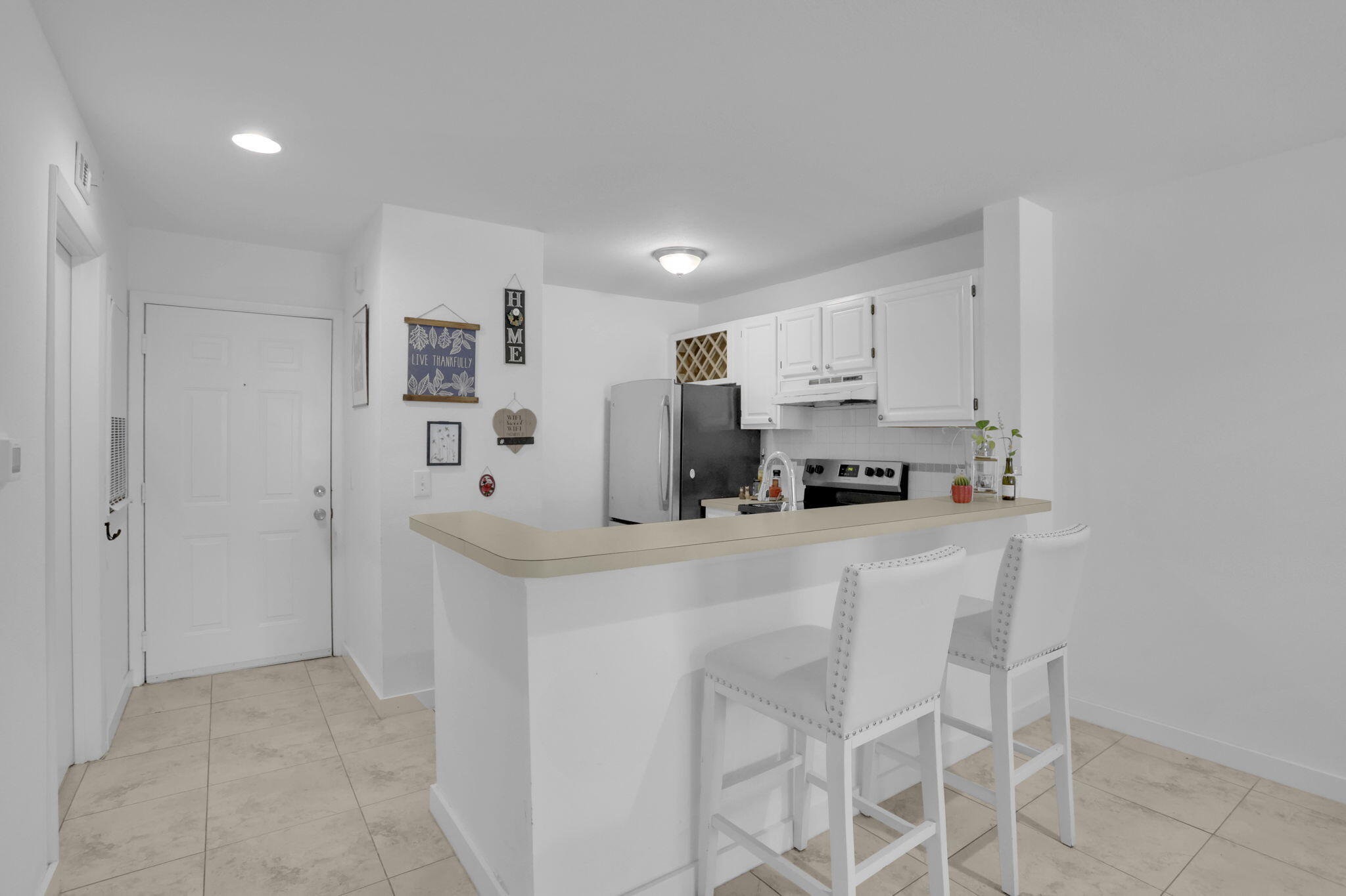 1825 Palm Cove Boulevard, Unit 7102 Delray Beach, FL 33445 - Photo 12 of 19 a kitchen with stainless steel appliances a refrigerator and a stove top oven