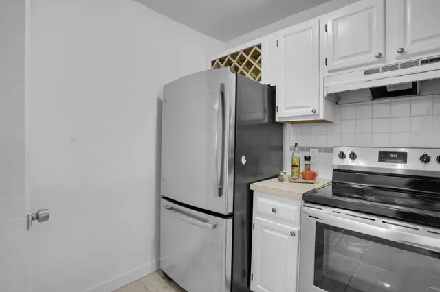 a kitchen with stainless steel appliances white cabinets and a refrigerator