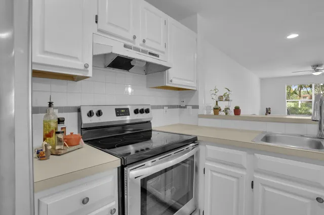 a kitchen with white cabinets and appliances