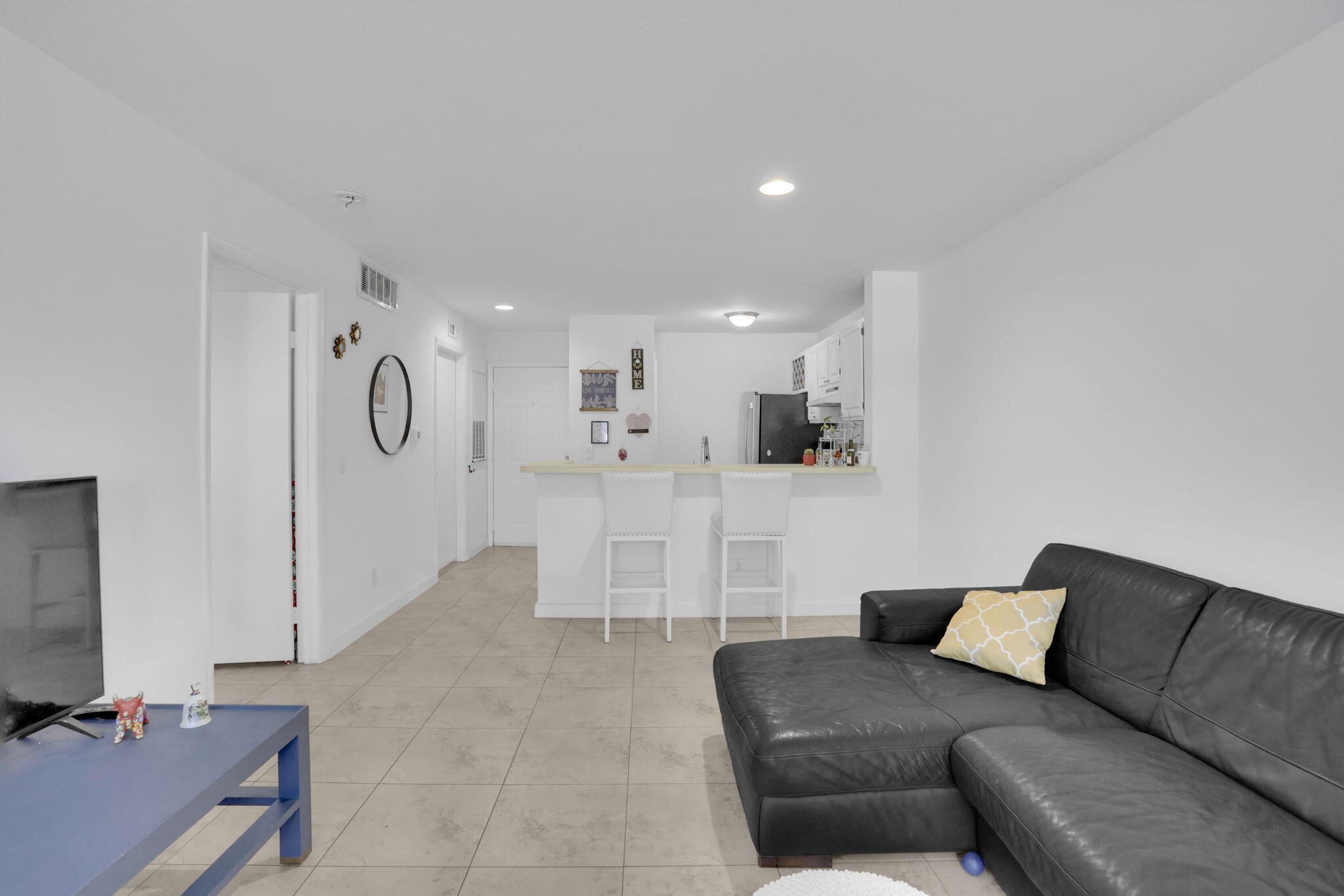 1825 Palm Cove Boulevard, Unit 7102 Delray Beach, FL 33445 - Photo 18 of 19 a living room with furniture and a flat screen tv