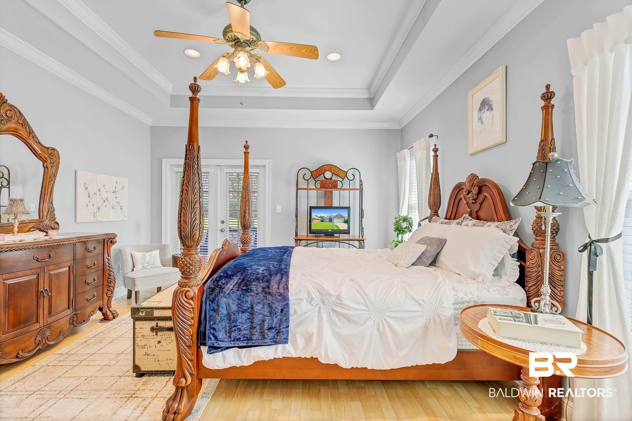 213 Hemingway Loop Foley, AL 36535 - Photo 27 of 69 Bedroom featuring multiple windows, a tray ceiling, light wood finished floors, a ceiling fan, and ornamental molding