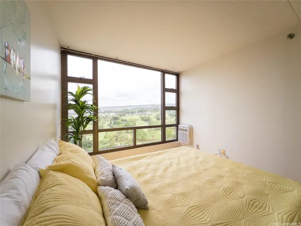 a bed sitting in a bedroom next to a large window