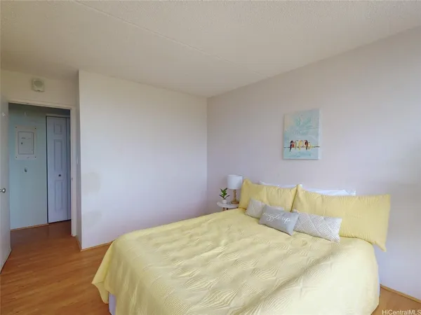 a bedroom with a bed and wooden floor
