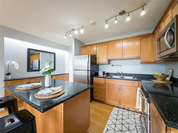 a kitchen with stainless steel appliances granite countertop a sink refrigerator stove microwave and cabinets
