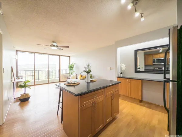 a kitchen with a sink and living room with a large window