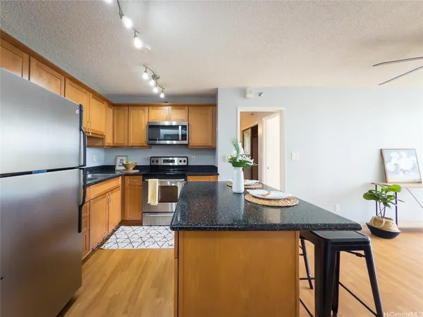 a kitchen with granite countertop stainless steel appliances a sink stove and refrigerator