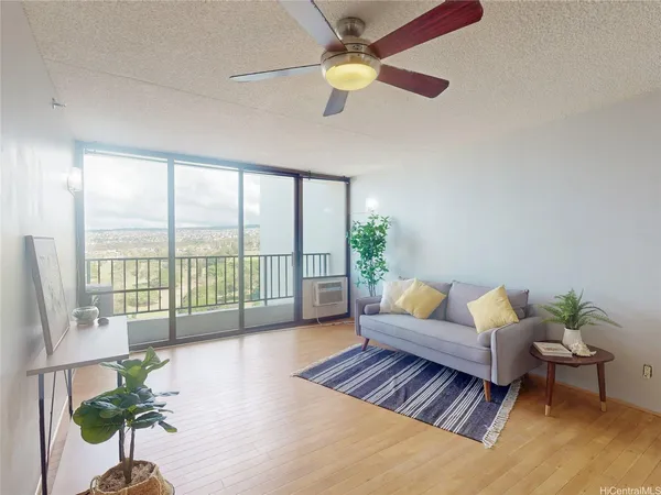 a living room with furniture and a large window with balcony view
