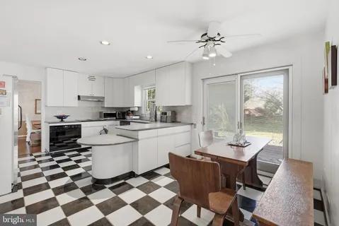 a kitchen with a sink a stove a refrigerator and white cabinets