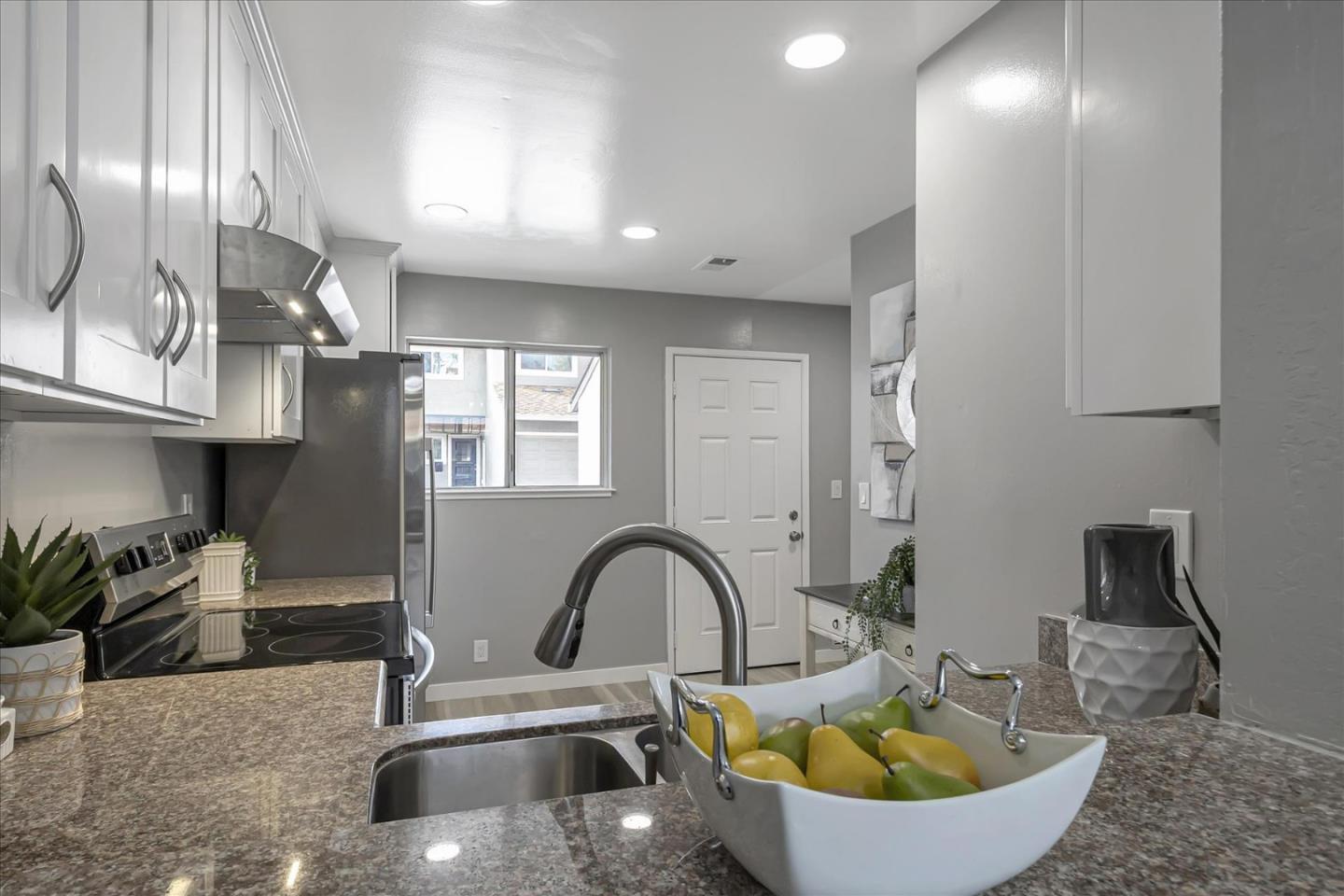 4796 Raspberry Place San Jose, CA 95129 - Photo 8 of 37 a kitchen with a sink and a stove with wooden floor